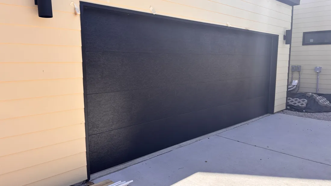 One wide garage door with a single ceiling-mounted opener after an Edge Garage Doors two-to-one conversion in the Austin area